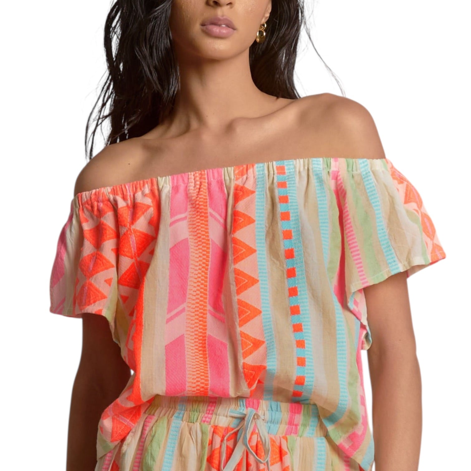 Woman wearing a colorful off-shoulder top with geometric patterns on a white background