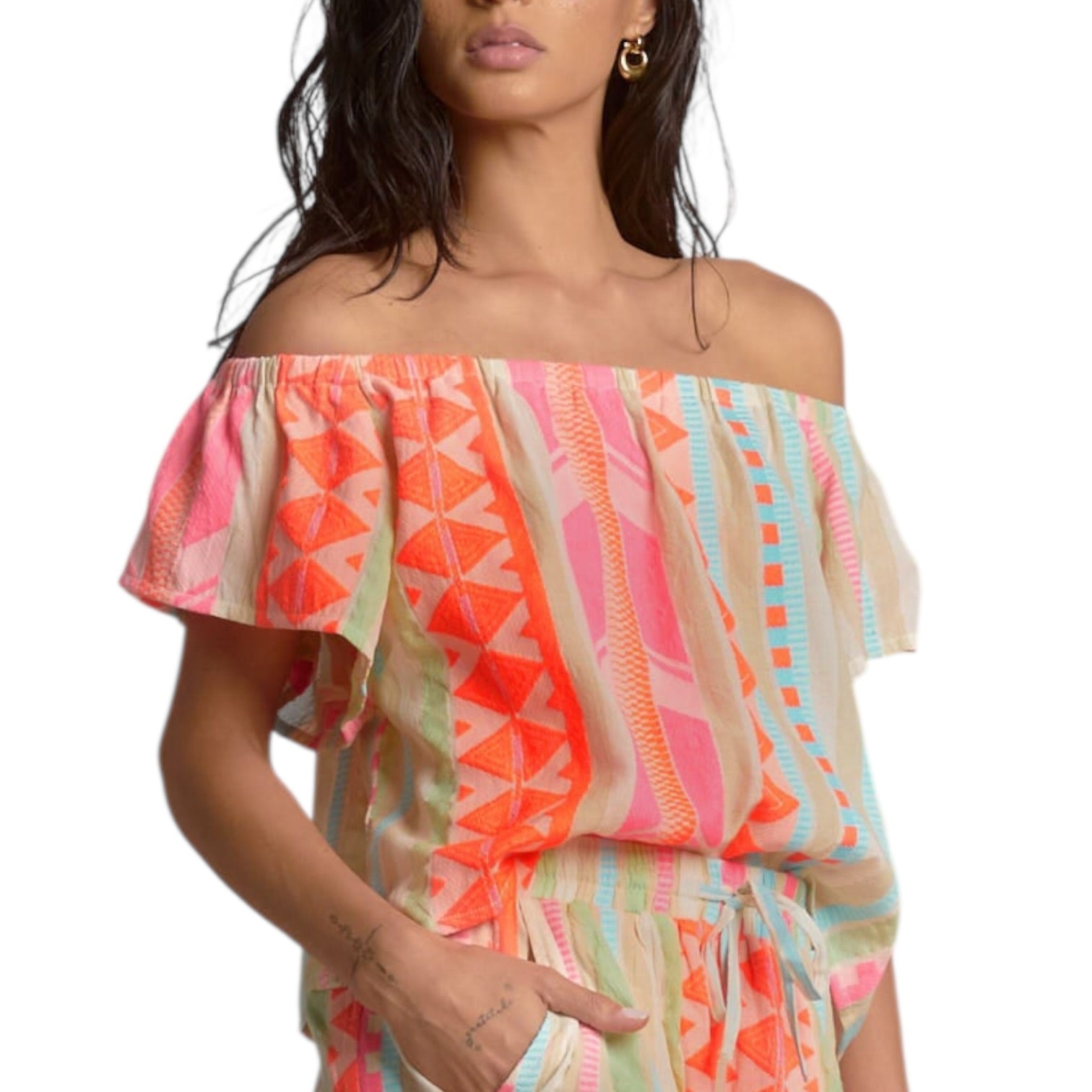Woman wearing a colorful off-shoulder top with geometric pattern on a white background