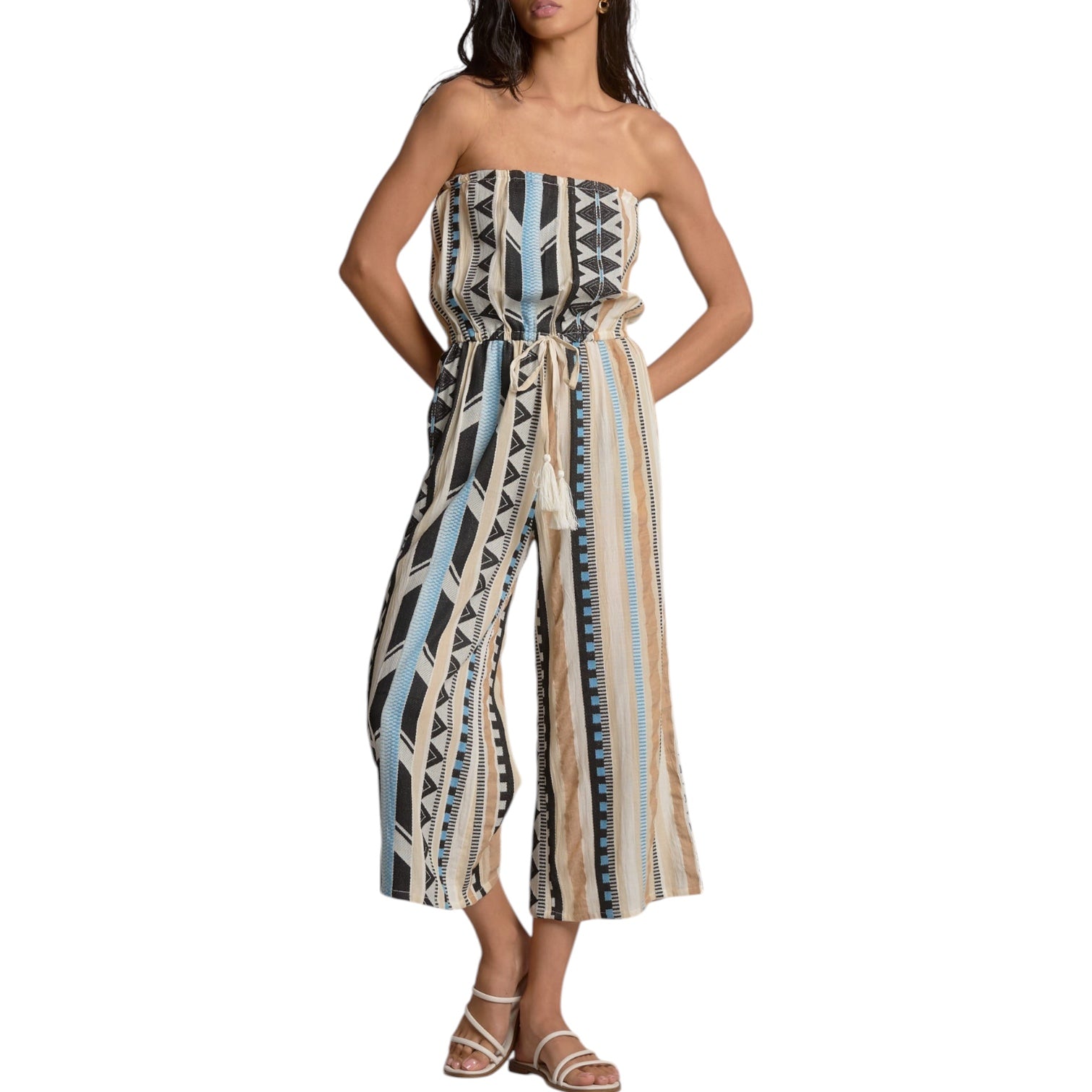 Woman wearing a strapless, patterned jumpsuit on a white background