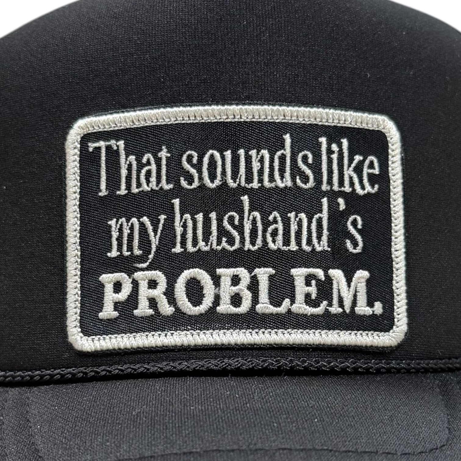 Black cap with a humorous embroidered patch on the back