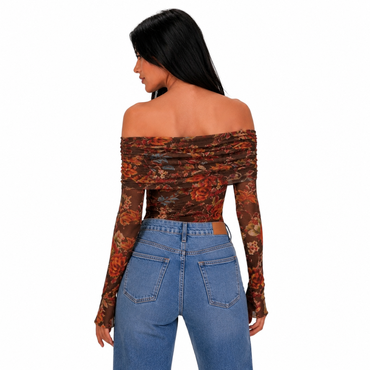 A woman shown from the back wearing a ruched off-the-shoulder long-sleeve bodysuit with a brown, orange, and red floral pattern, paired with blue jeans, against a plain white background.