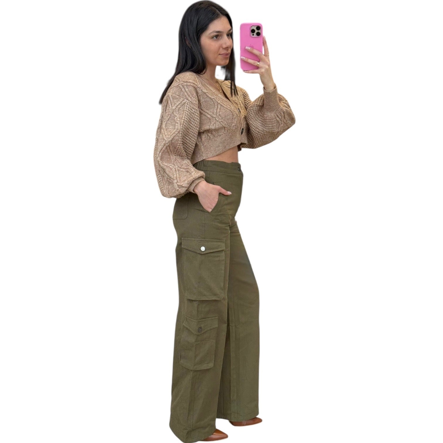 Woman taking a selfie wearing a beige cropped top and olive green cargo pants on a white background