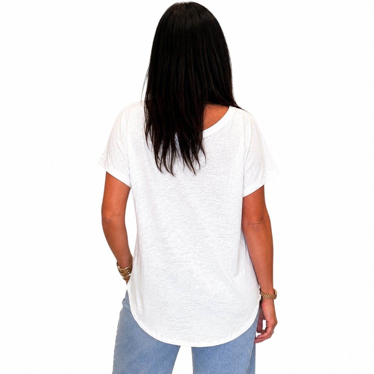 A woman viewed from behind wearing a white short-sleeve V-neck t-shirt and light blue jeans, set against a plain white background.