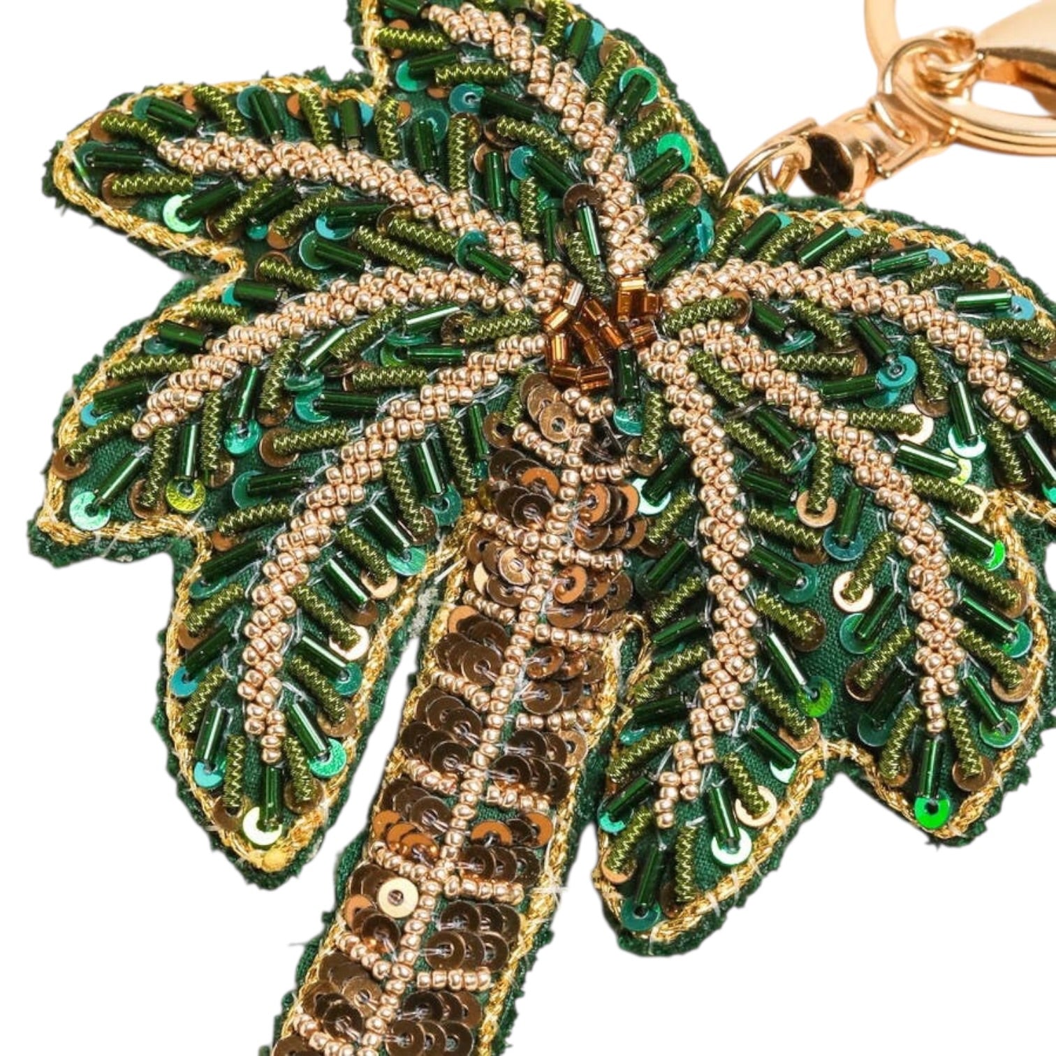 Decorative keychain with palm leaf design featuring green, gold, and brown colors on a white background.