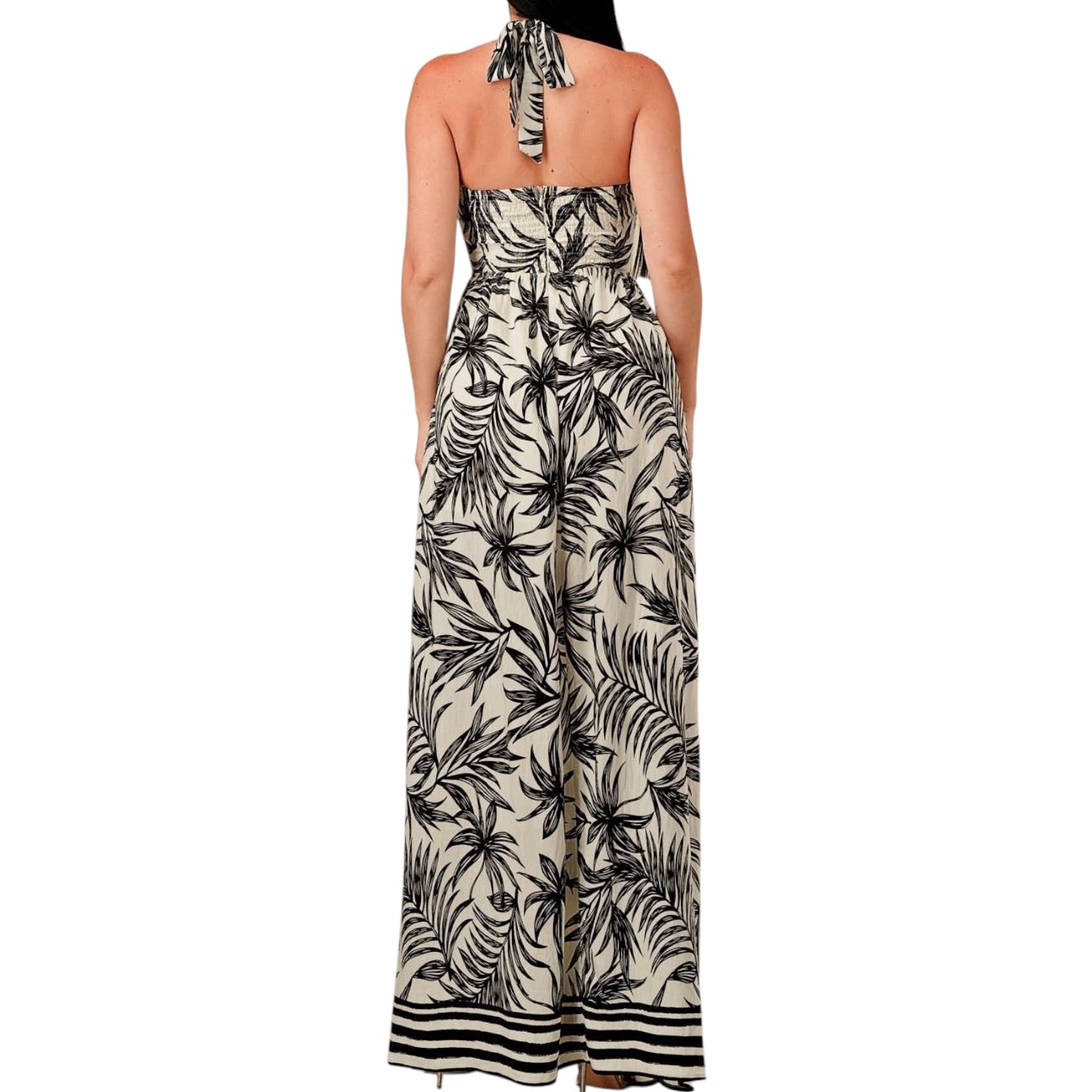 Woman wearing a black and white floral halter neck dress on a white background
