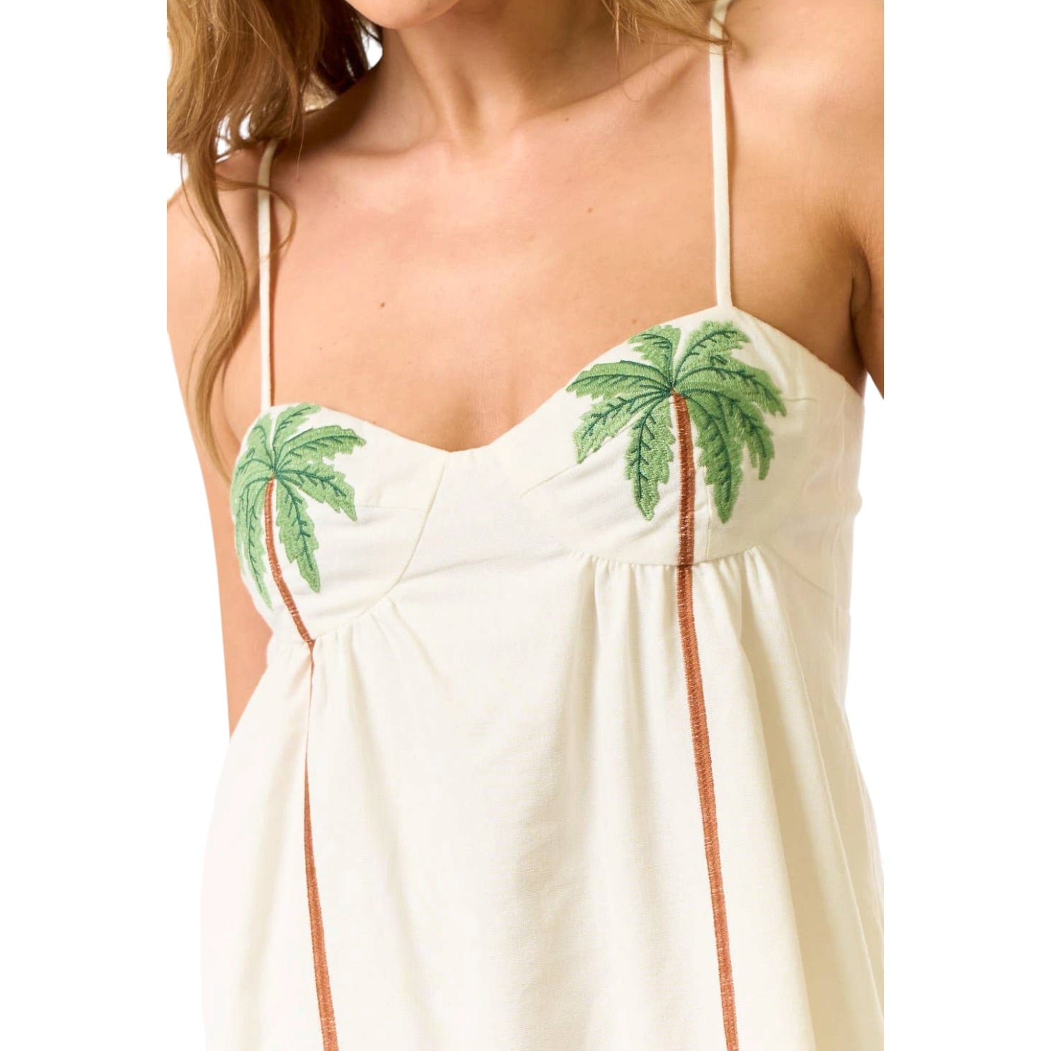 White dress with green palm tree designs on a white background