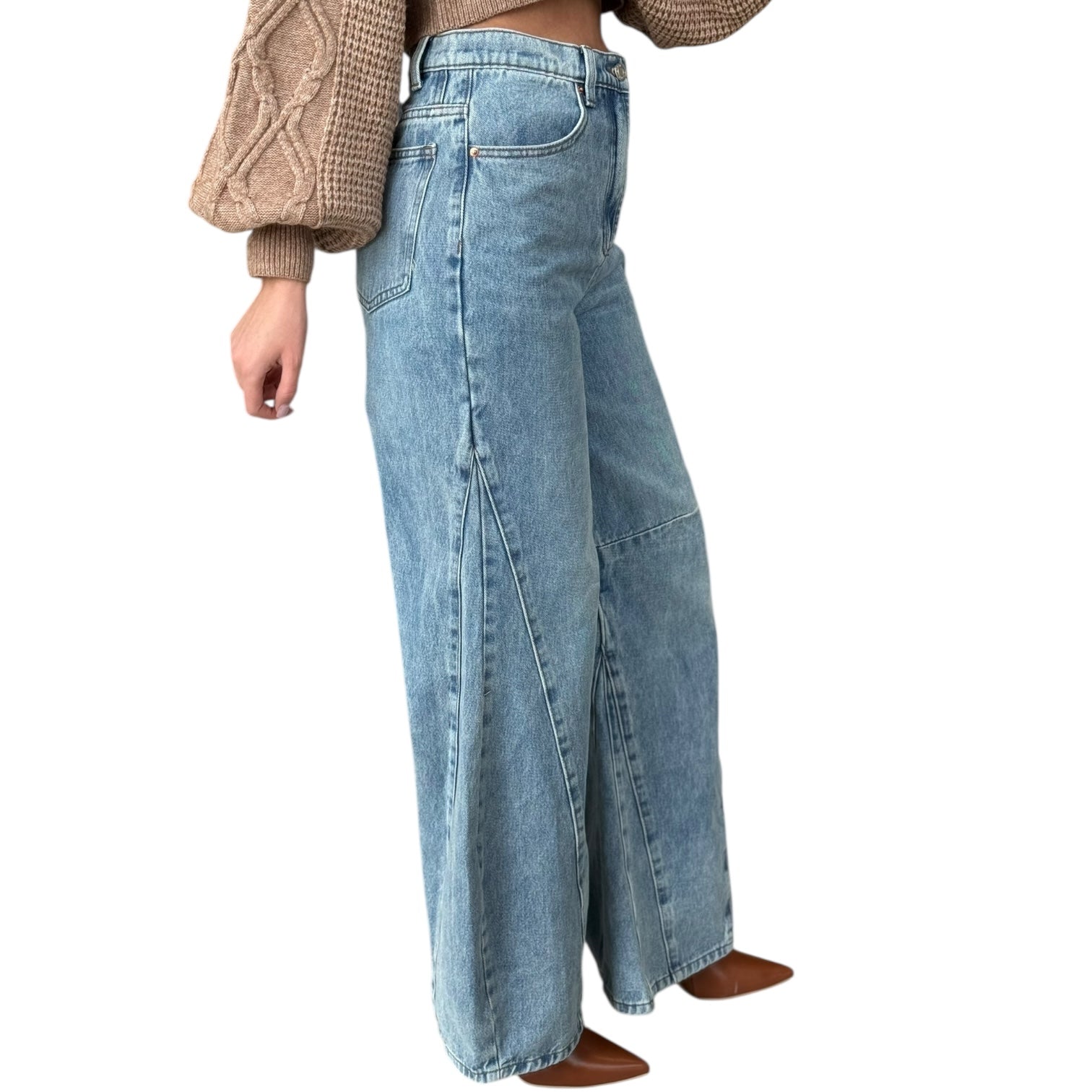 Person wearing wide-leg jeans on a white background