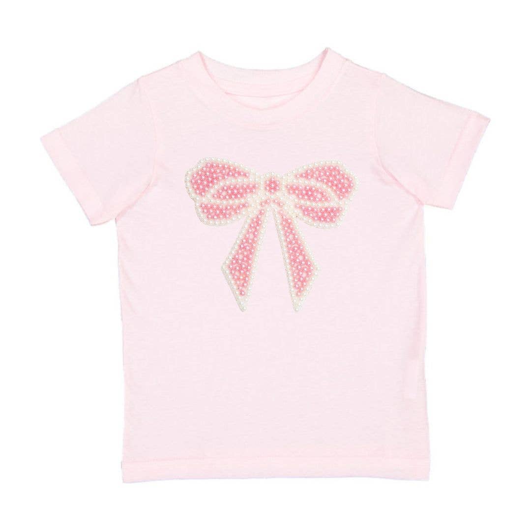 Pink t-shirt with a decorative bow design on a white background