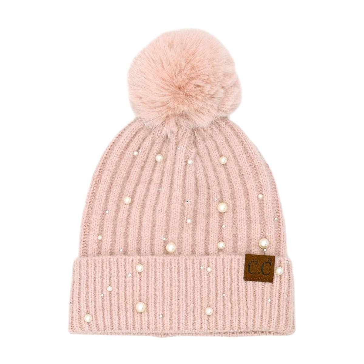 A light pink ribbed knit beanie hat with a fluffy pom-pom on top, decorated with scattered faux pearls and small rhinestones, featuring a brown leather patch with 'CG' on the folded cuff.