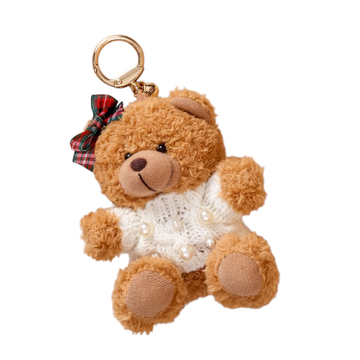 A plush teddy bear keychain charm in warm brown, wearing a white knit sweater with faux pearls and a red plaid bow on its head, attached to a gold key ring, shown on a plain white background.
