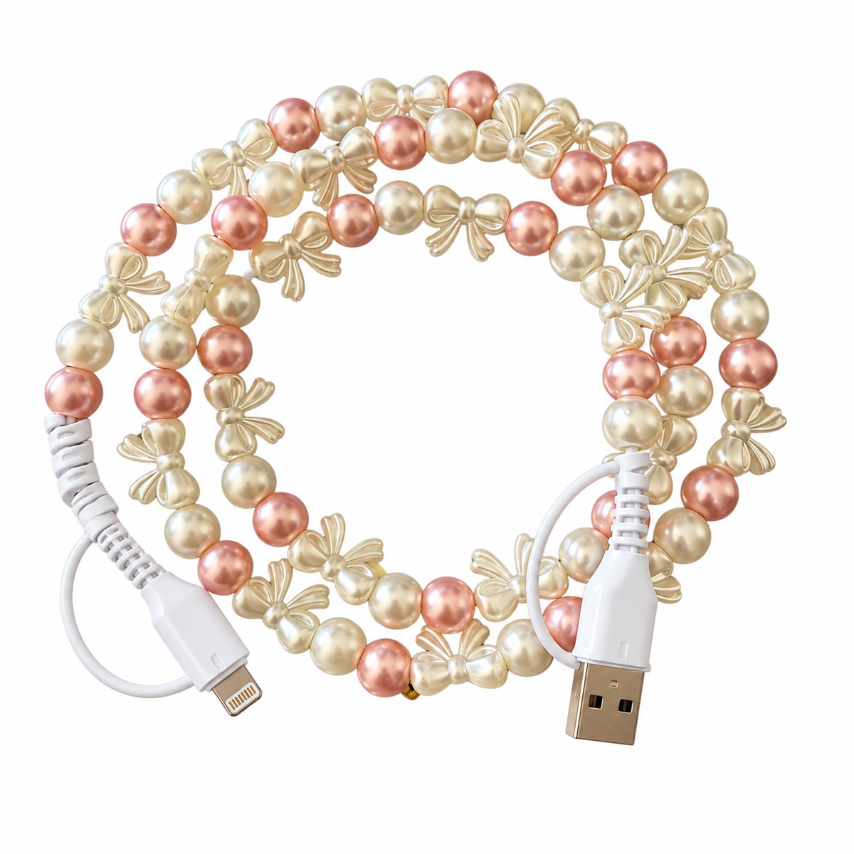 A decorative USB charging cable coiled in a circle, featuring faux pearl beads in white, cream, and soft pink, accented with gold-tone bow and leaf charms, with white braided cable sections and USB-A to Lightning connectors.