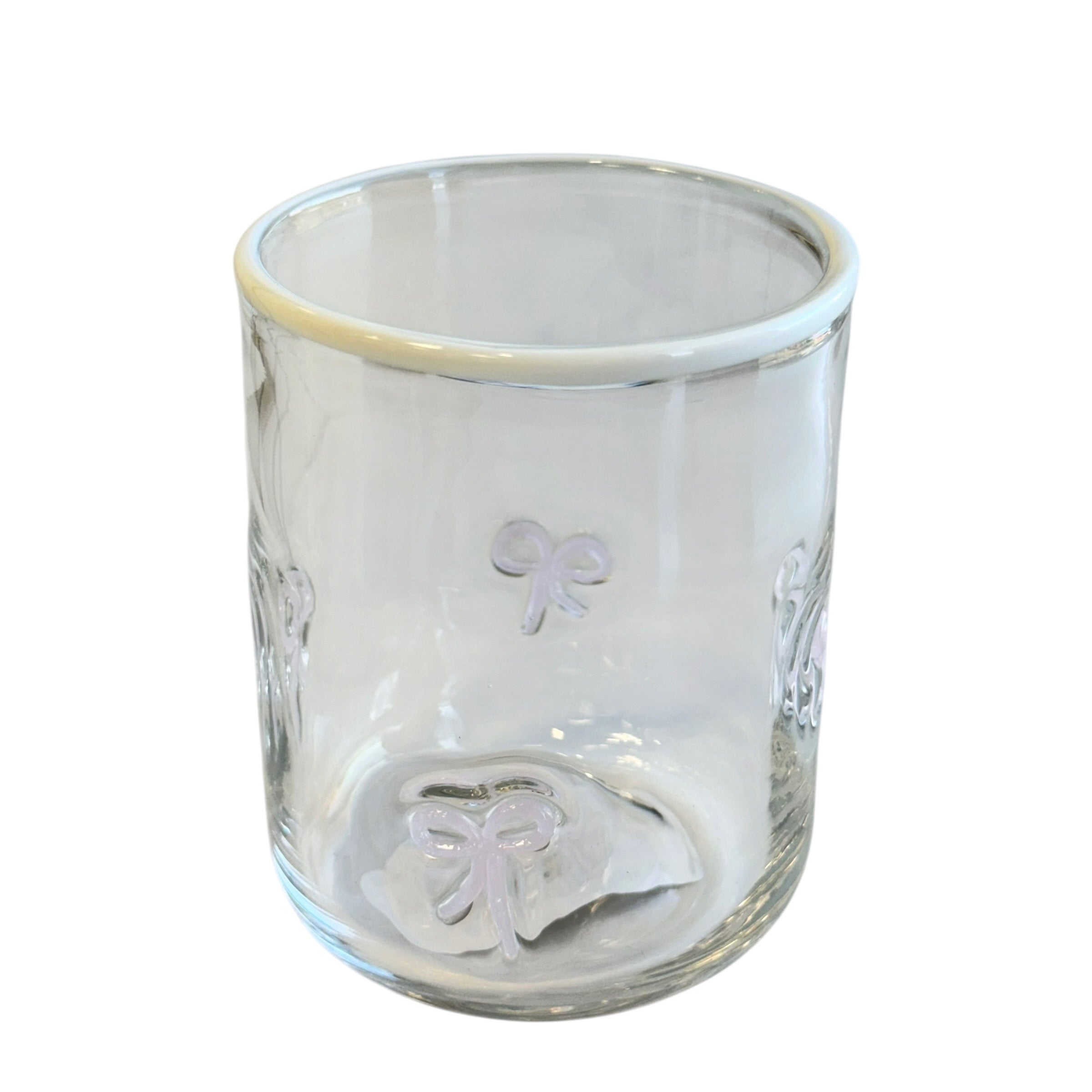 Clear glass tumbler with embossed designs on a white background