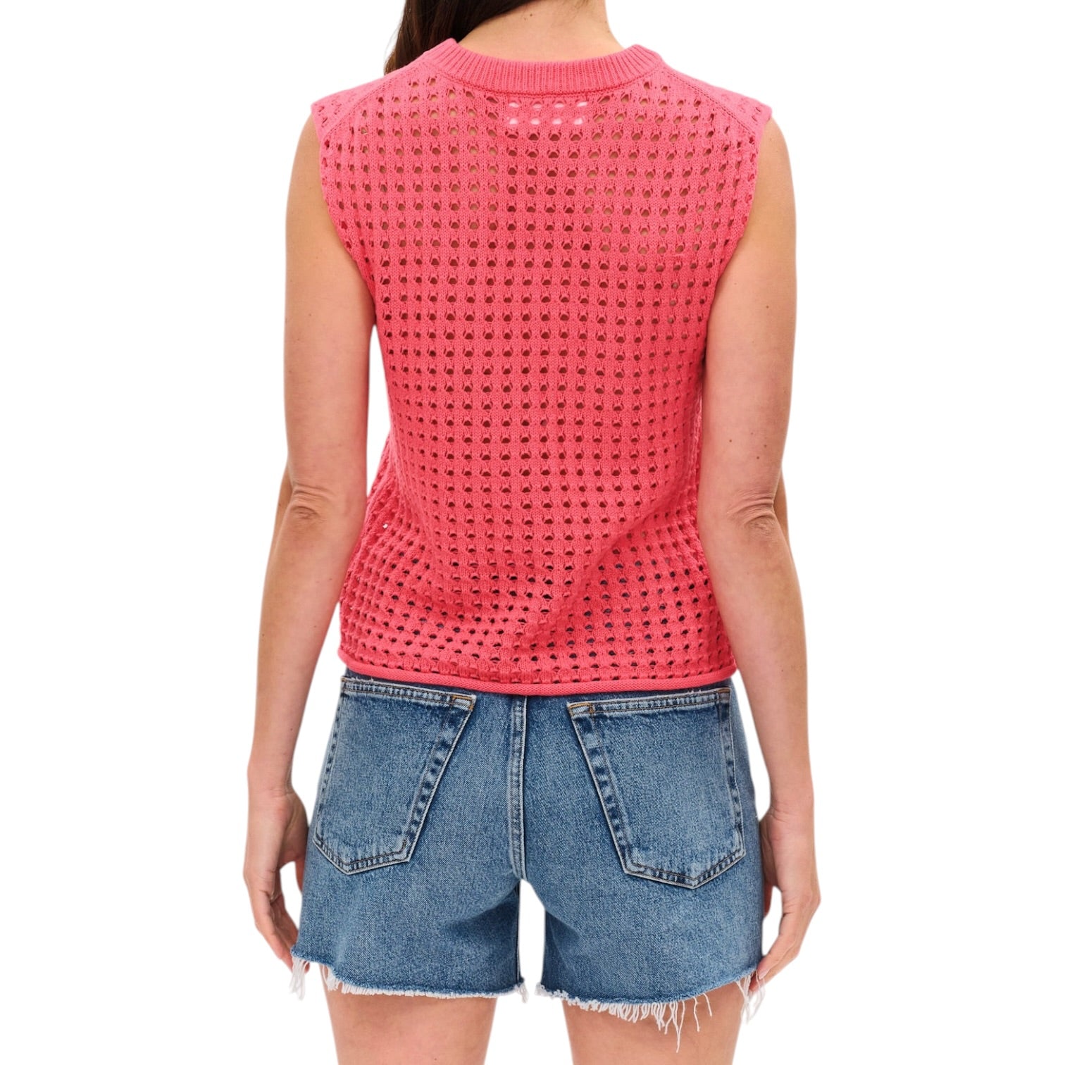 Person wearing a pink sleeveless top and denim shorts on a white background