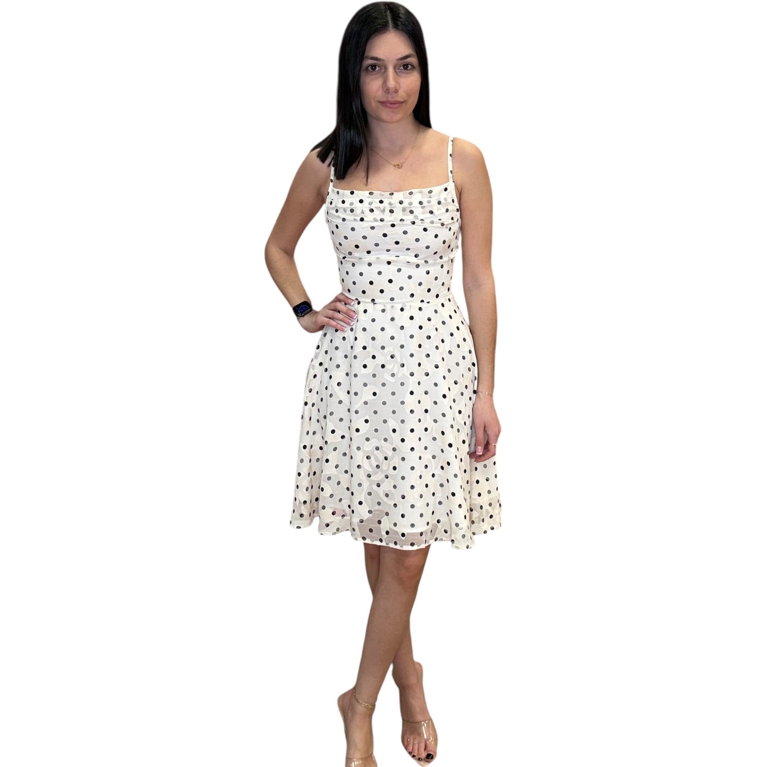 Woman wearing a white dress with black polka dots on a white background
