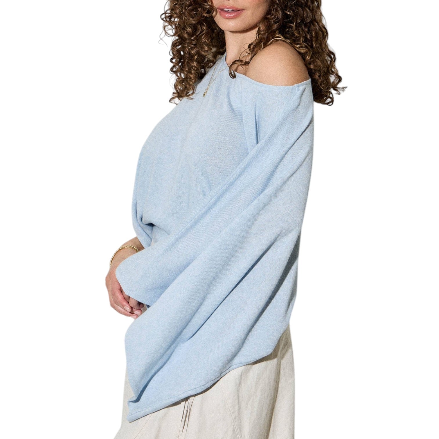 Woman wearing a light blue wrap over one shoulder on a white background
