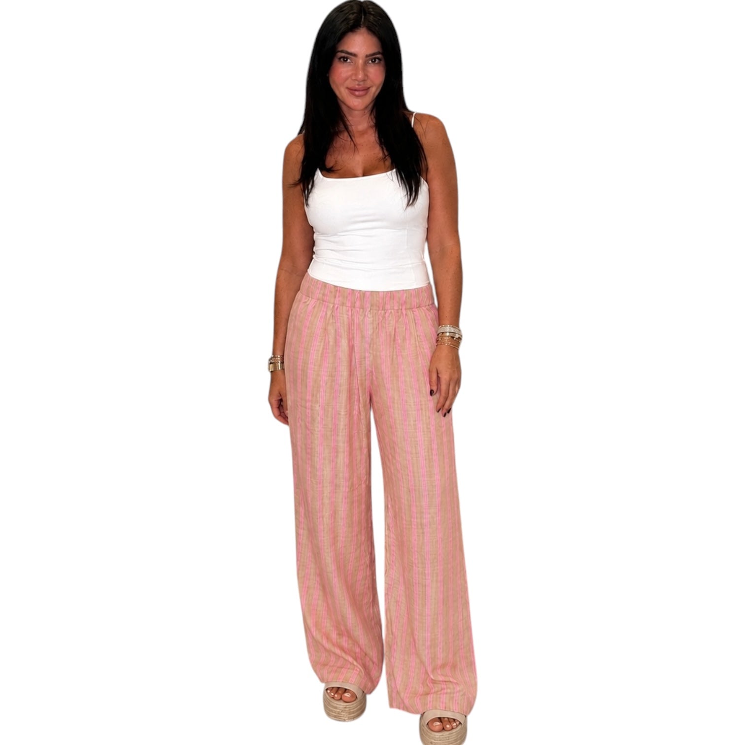 Woman wearing a white top and pink striped pants on a white background