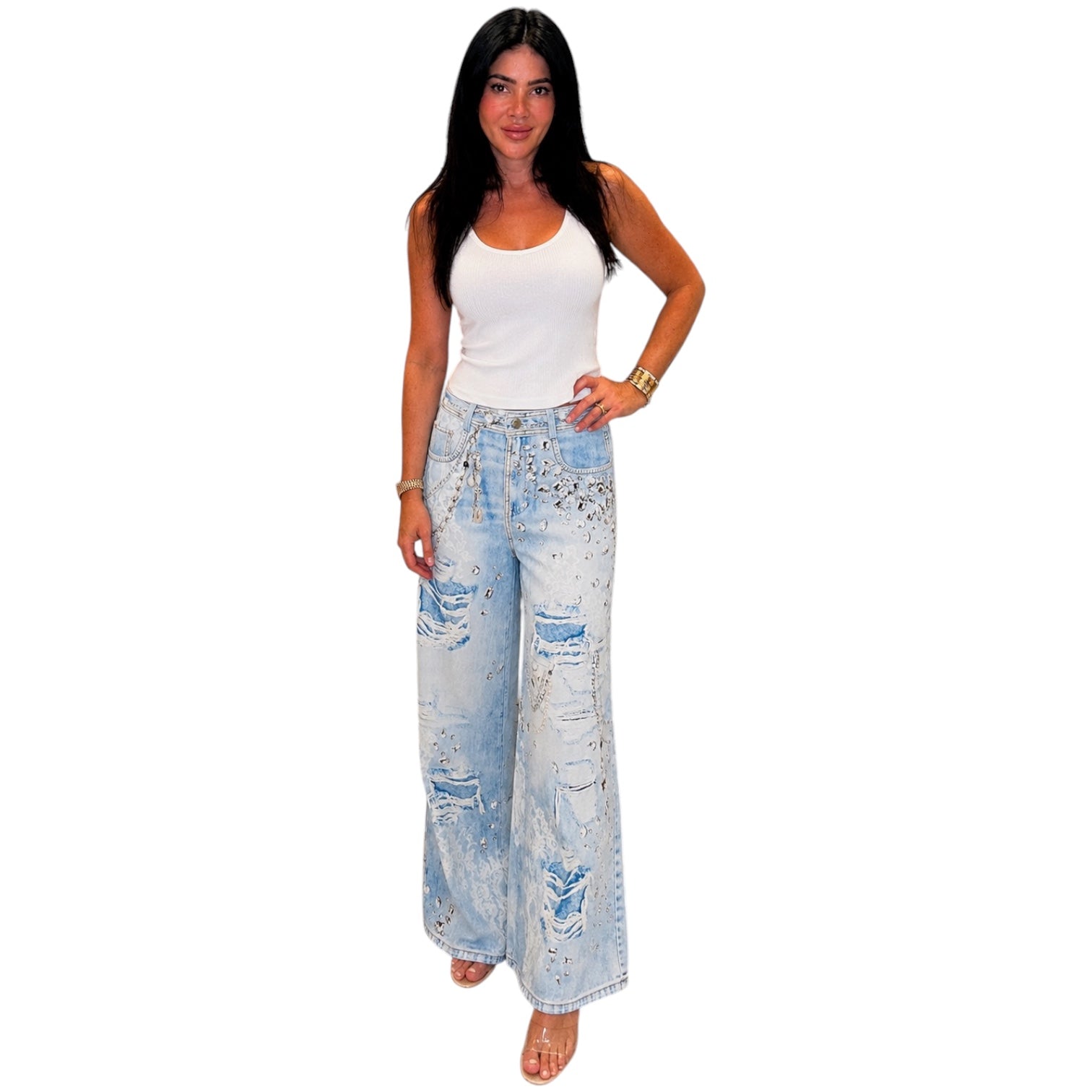 Woman wearing light blue distressed wide-leg jeans and a white top on a white background