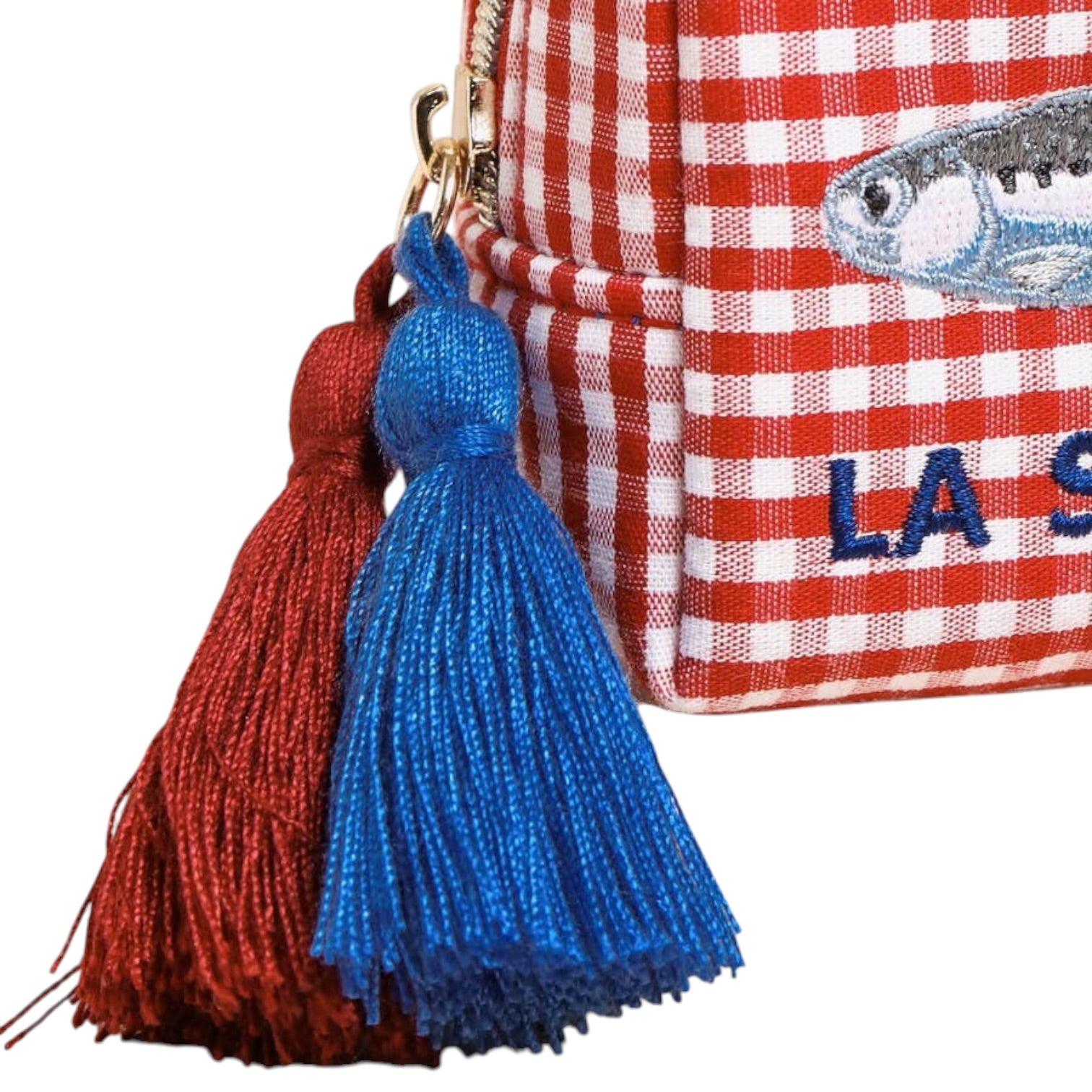 Red and white checkered bag with blue and red tassels on a white background