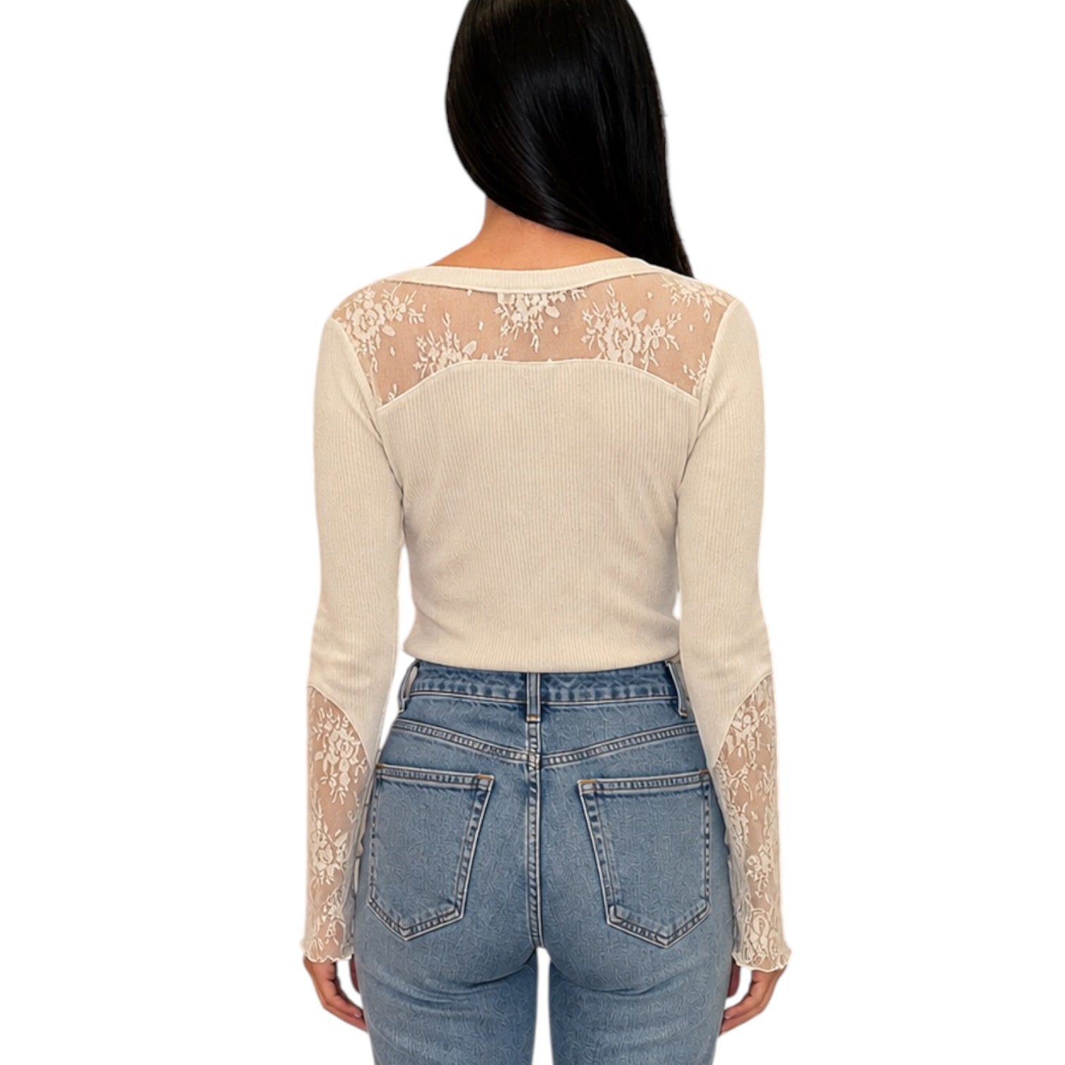 A woman shown from the back wearing a beige ribbed long-sleeve top with sheer lace panels across the shoulders and down the sleeves, paired with light blue jeans, against a plain white background.