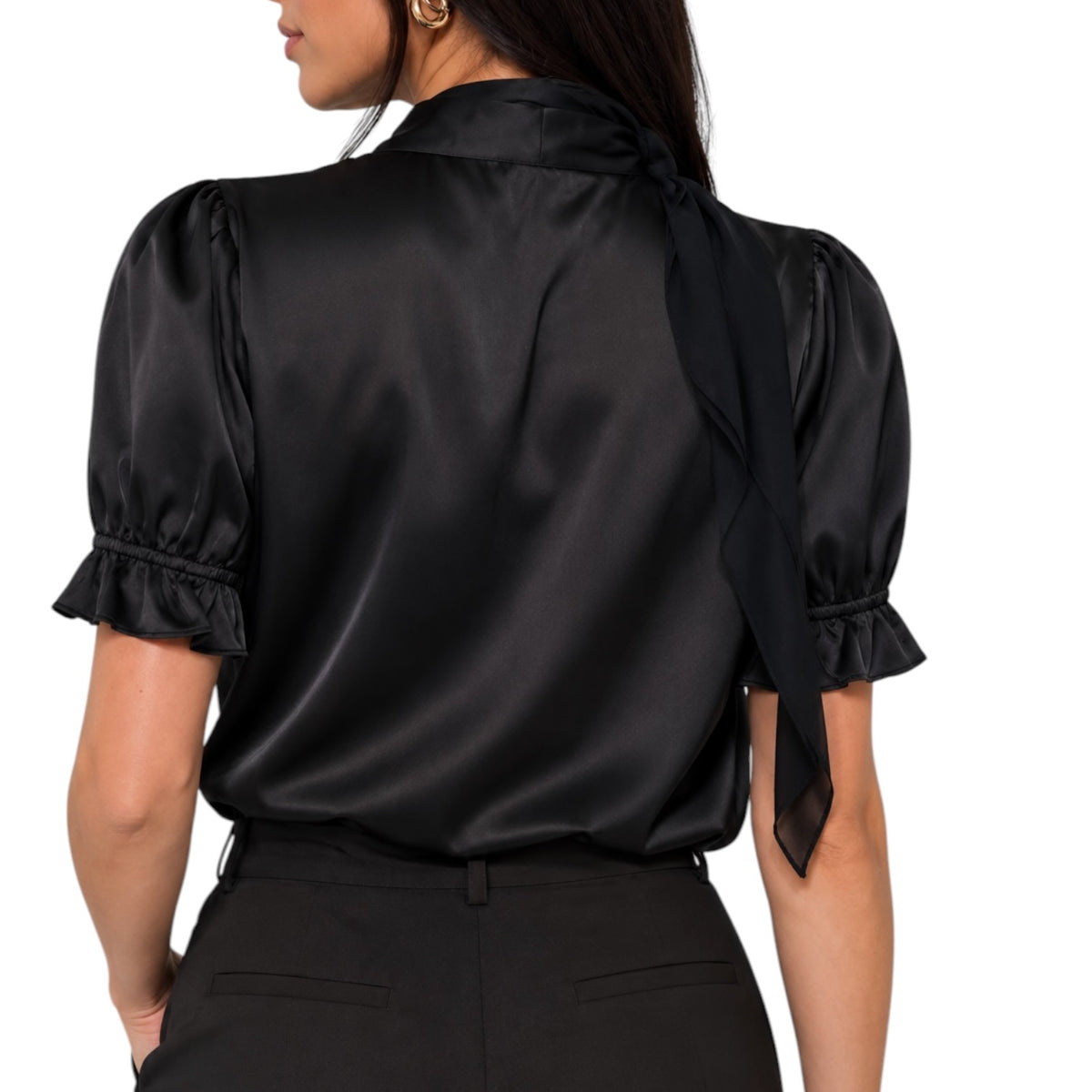 A woman shown from the back wearing a black satin blouse with short puff sleeves, ruffled cuffs, and a long tie at the back of the neck, paired with black pants against a plain white background.