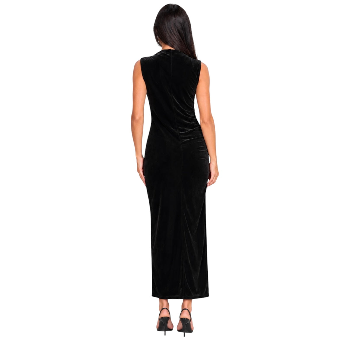 A woman viewed from the back wearing a sleeveless black velvet maxi dress with a draped neckline and gathered side detail, paired with black high heels, on a plain white background.