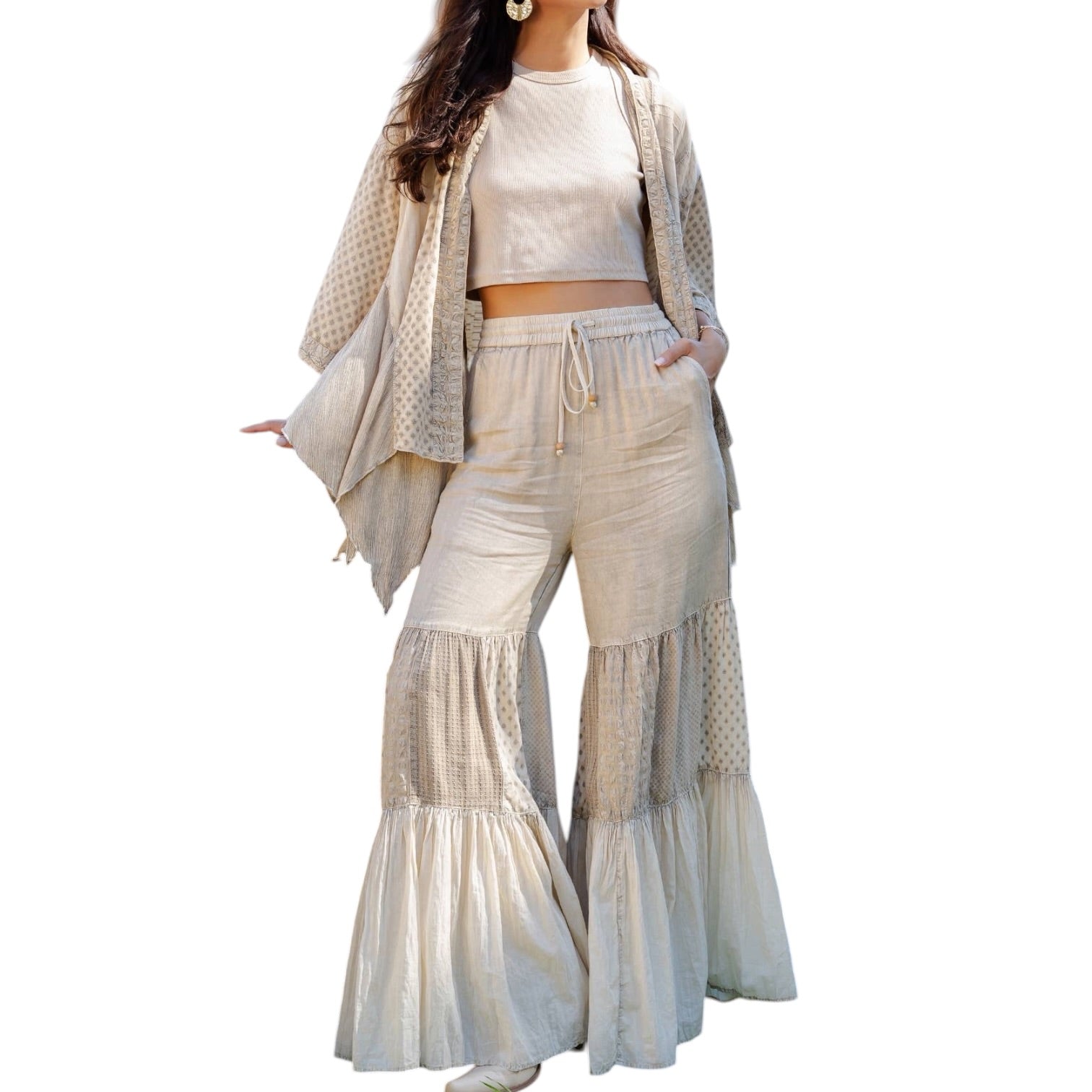 Woman wearing a beige outfit with a matching cardigan on a white background