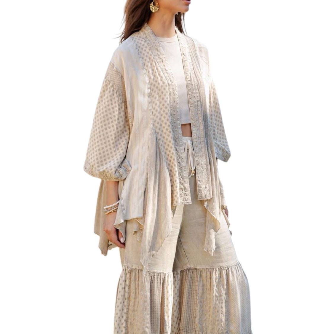 Woman wearing a beige layered outfit on a white background