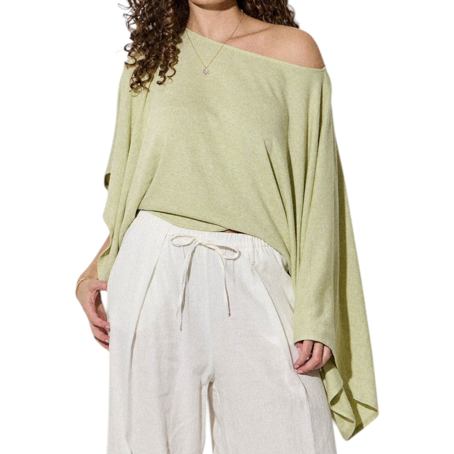 Woman wearing a light green off-shoulder top and white pants on a white background
