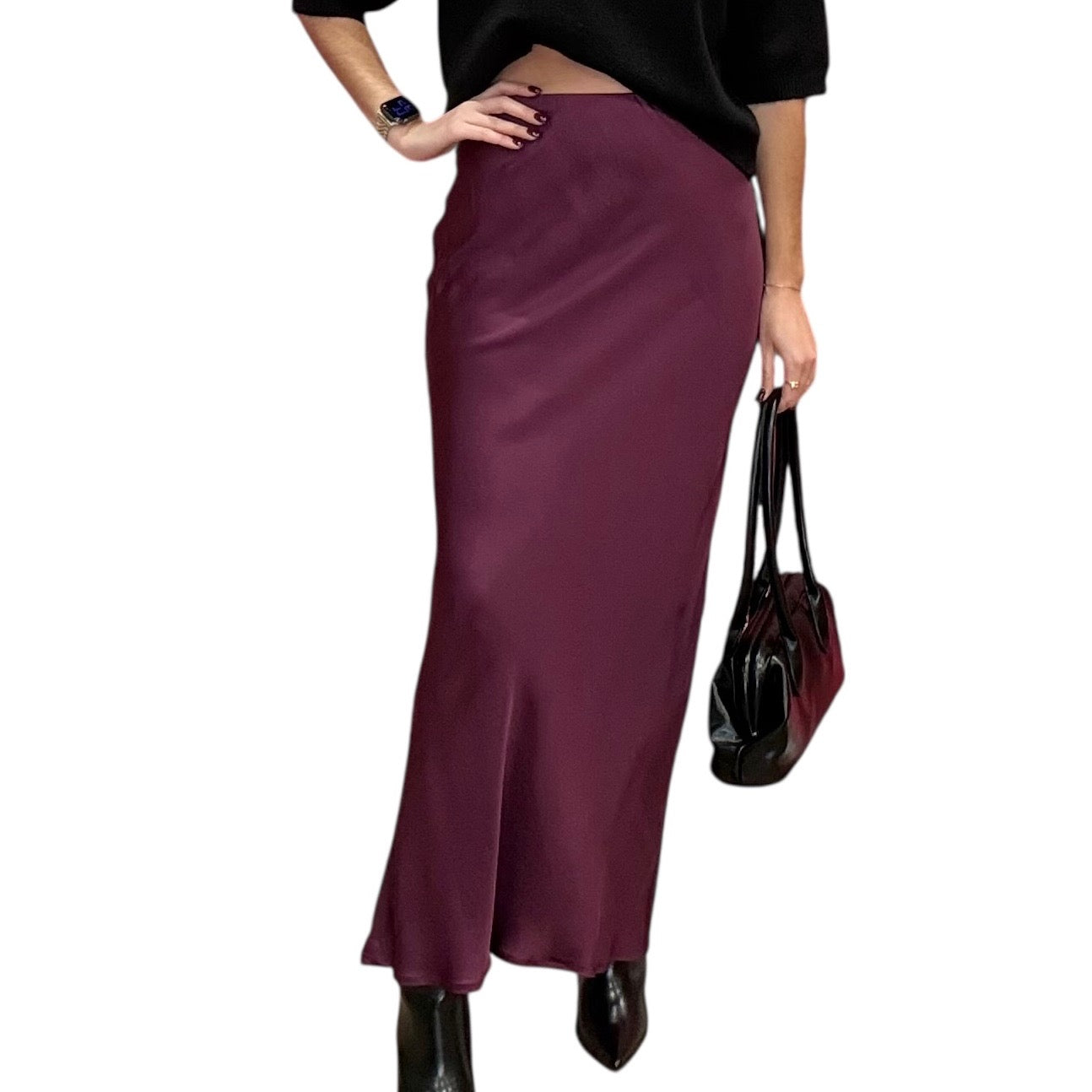 Person wearing a long burgundy skirt holding a matching handbag on a white background