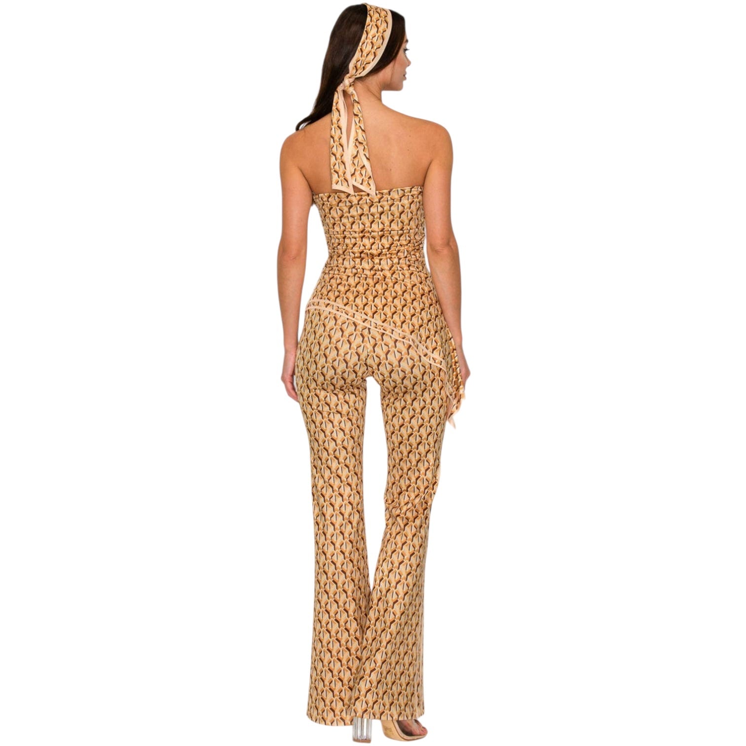 Woman wearing a patterned jumpsuit and headscarf on a white background