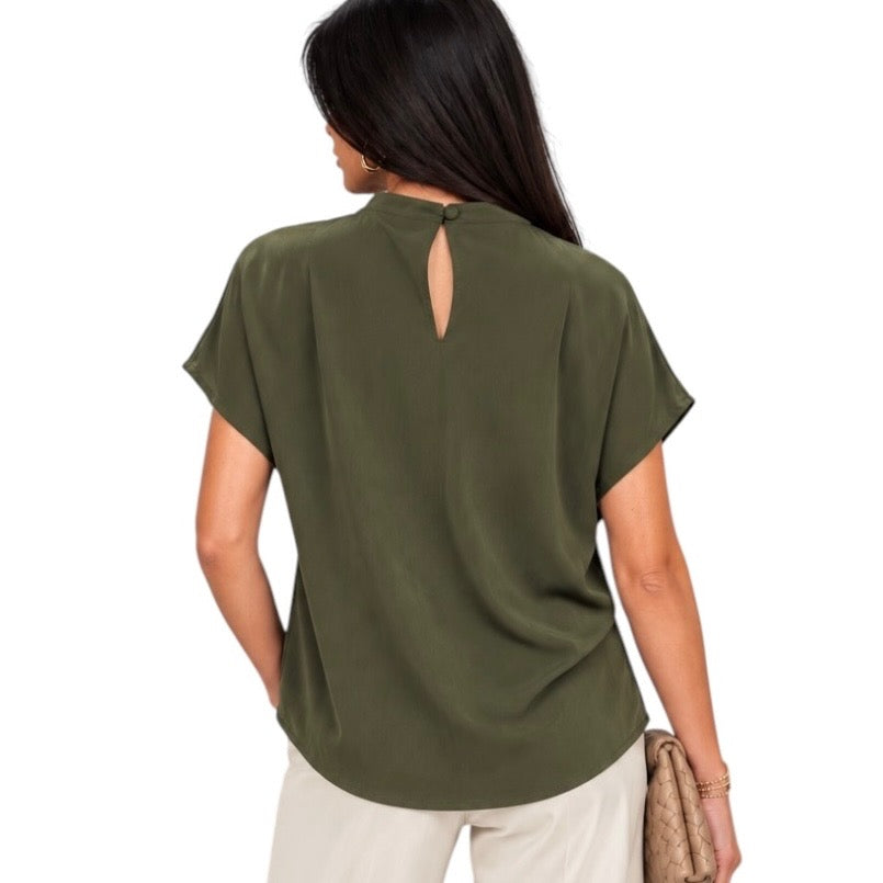 A woman shown from the back wearing an olive green short-sleeve blouse with a small keyhole cutout at the back, paired with light beige pants against a plain white background.