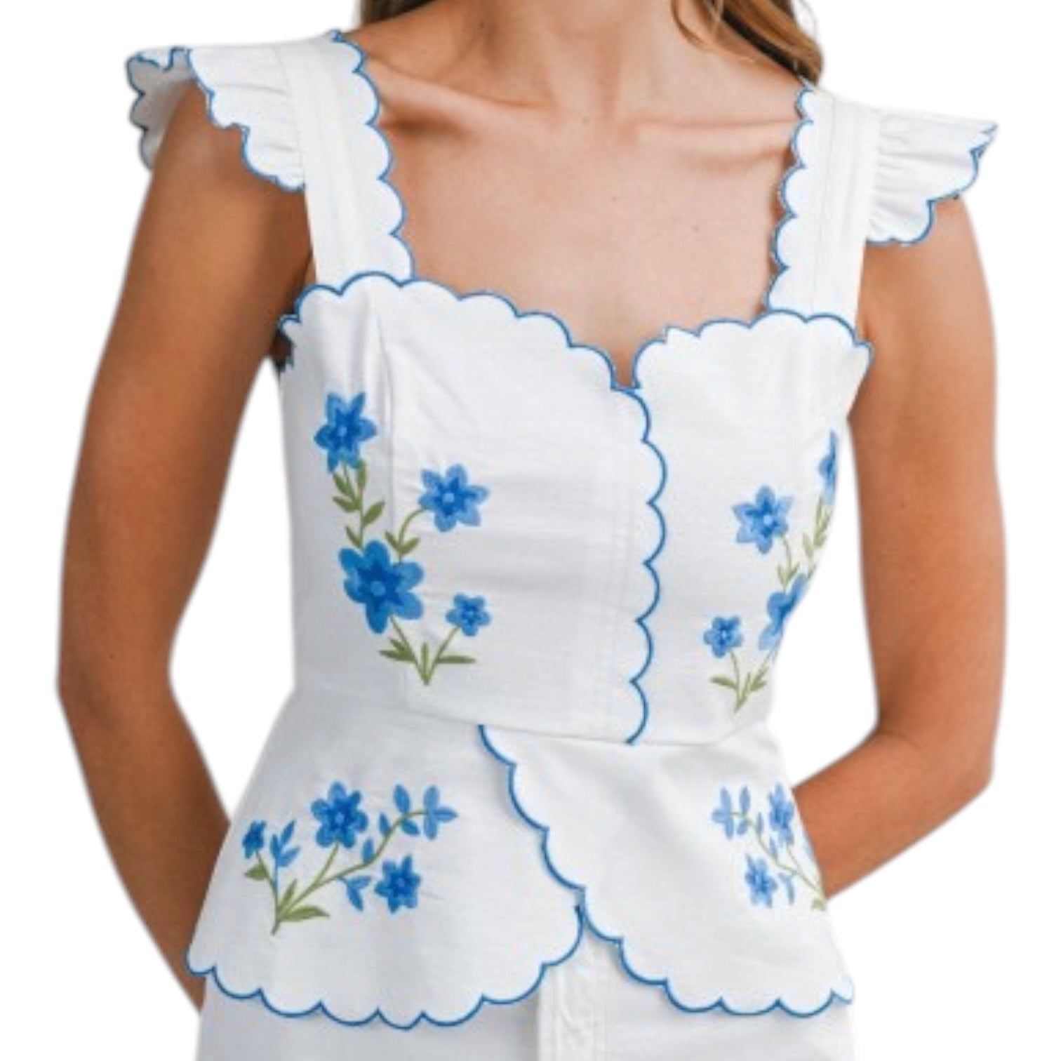 White top with blue floral embroidery on a white background