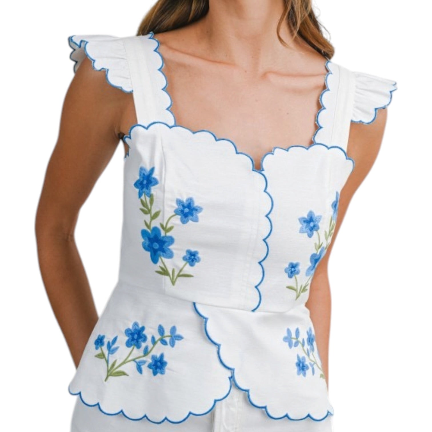 White sleeveless top with blue floral embroidery on a white background