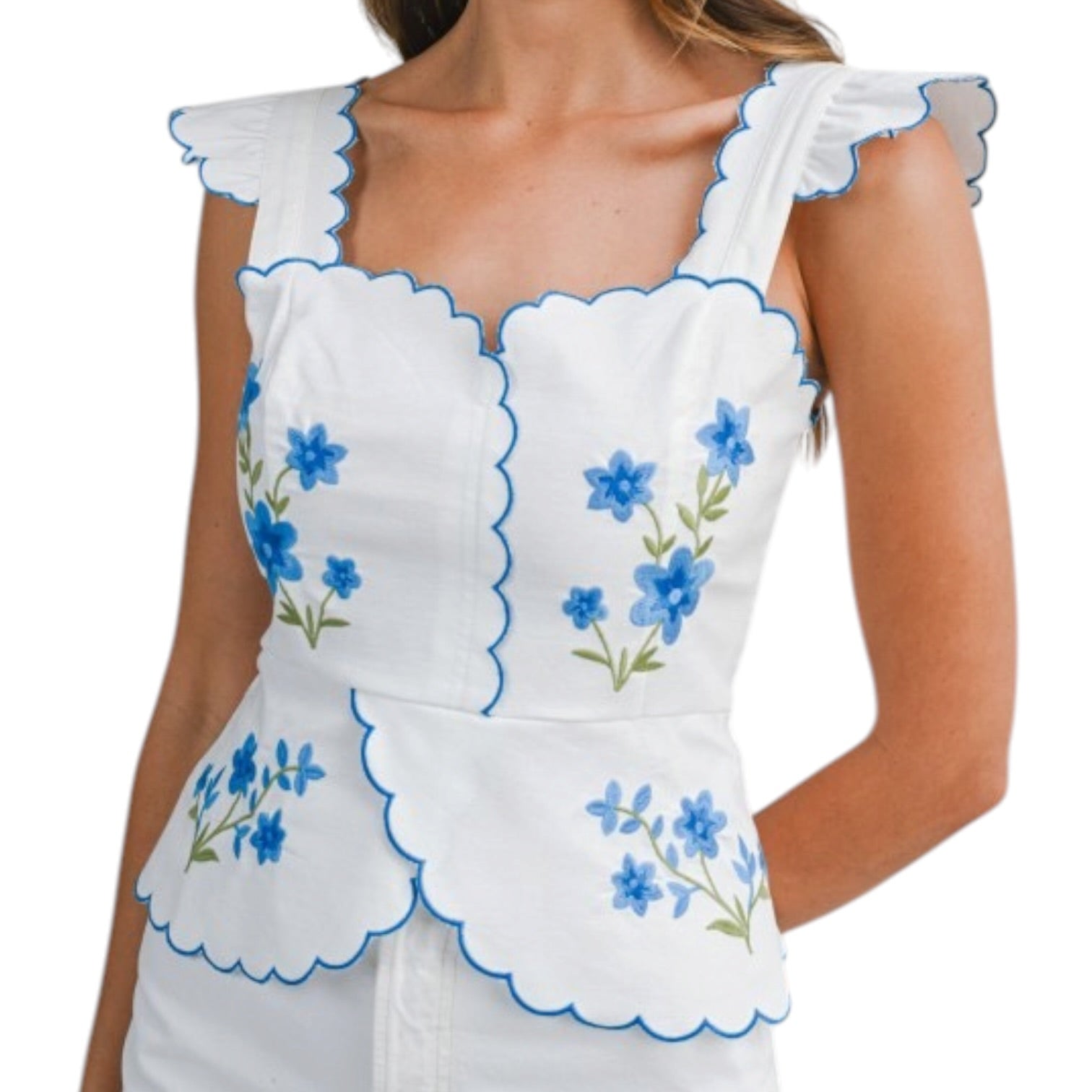 White top with blue floral embroidery on a white background