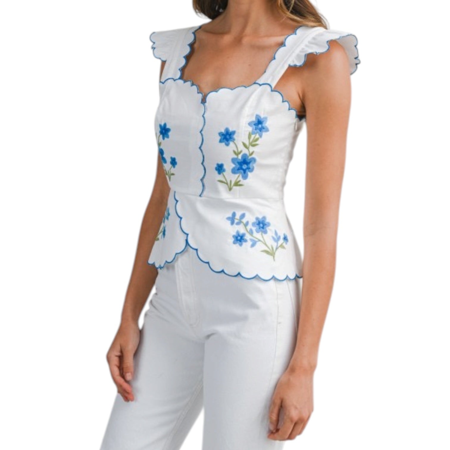 White sleeveless top with blue floral embroidery on a white background