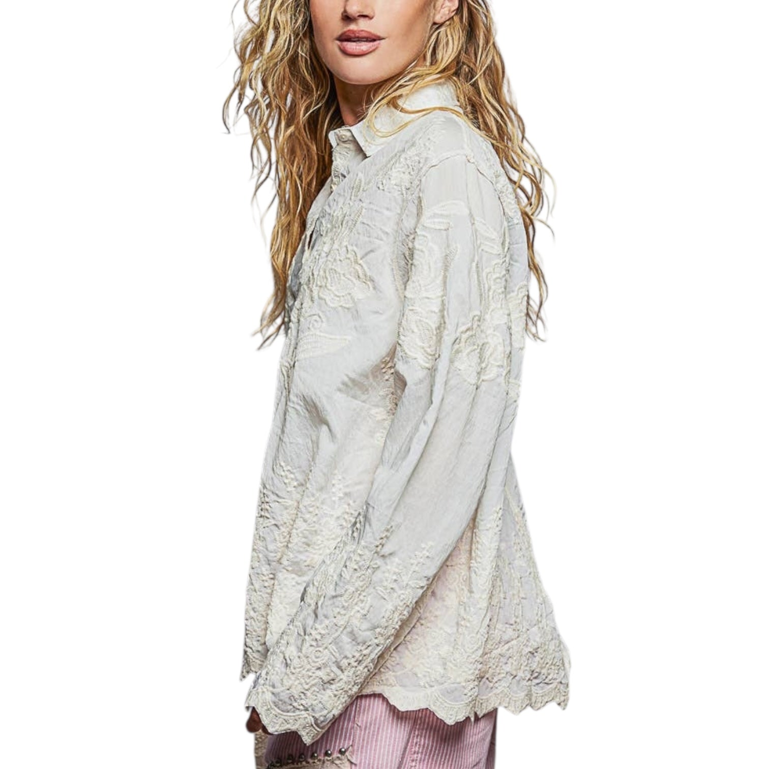Woman wearing a light-colored lace blouse on a white background