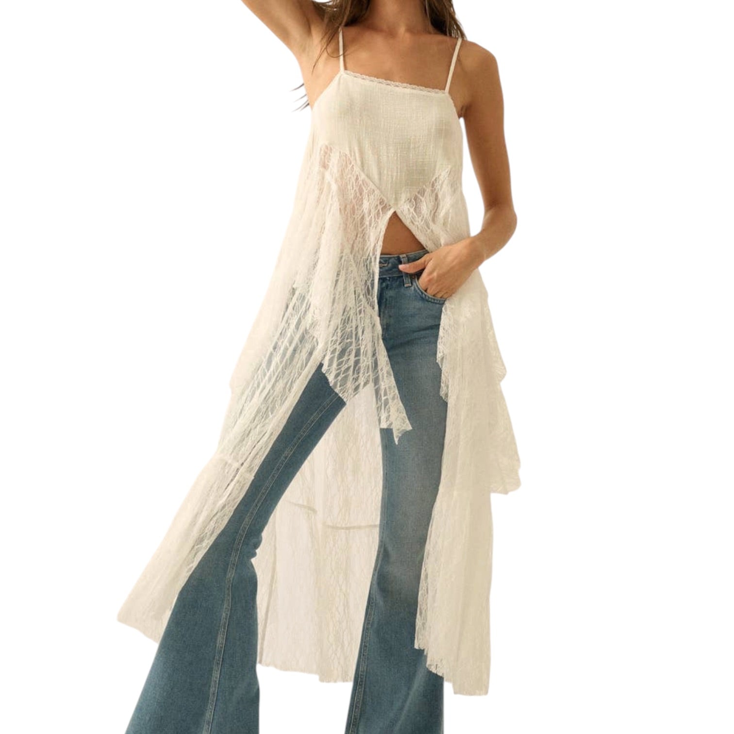 Woman wearing a white lace cover-up over a swimsuit with blue jeans on a white background