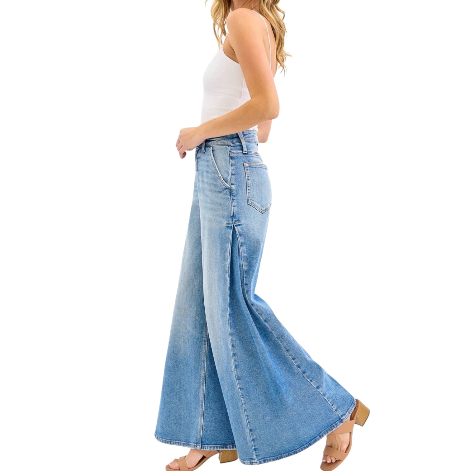 Woman wearing light blue flared jeans on a white background