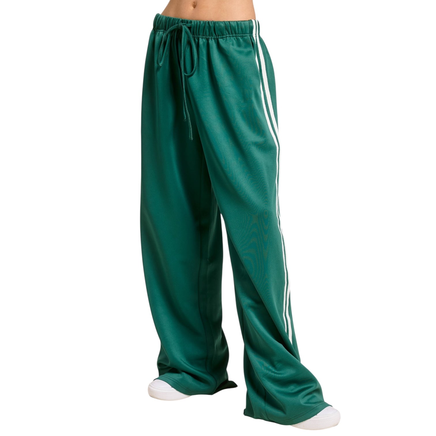 Green track pants with white stripes on a white background