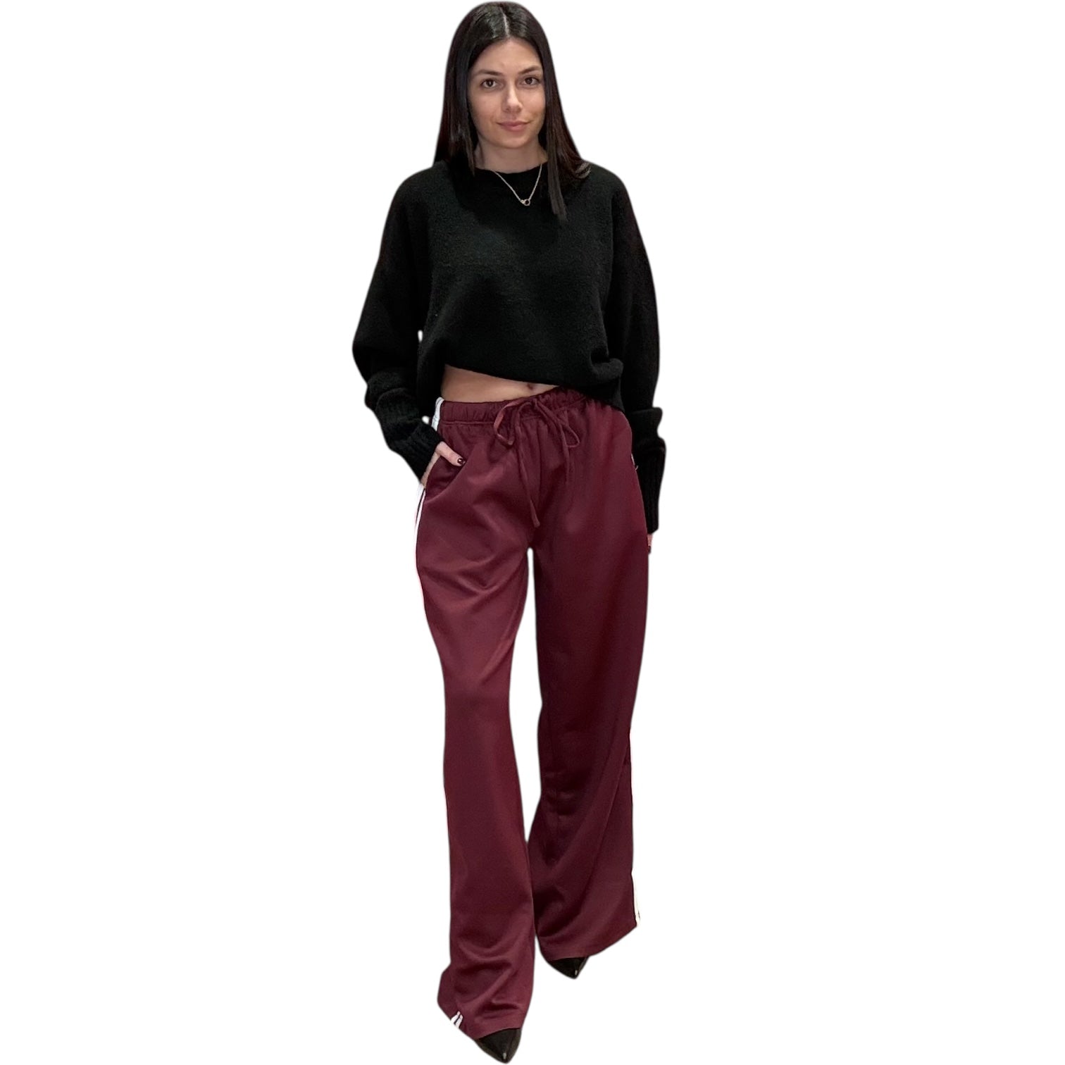 Woman wearing a black top and maroon pants on a white background