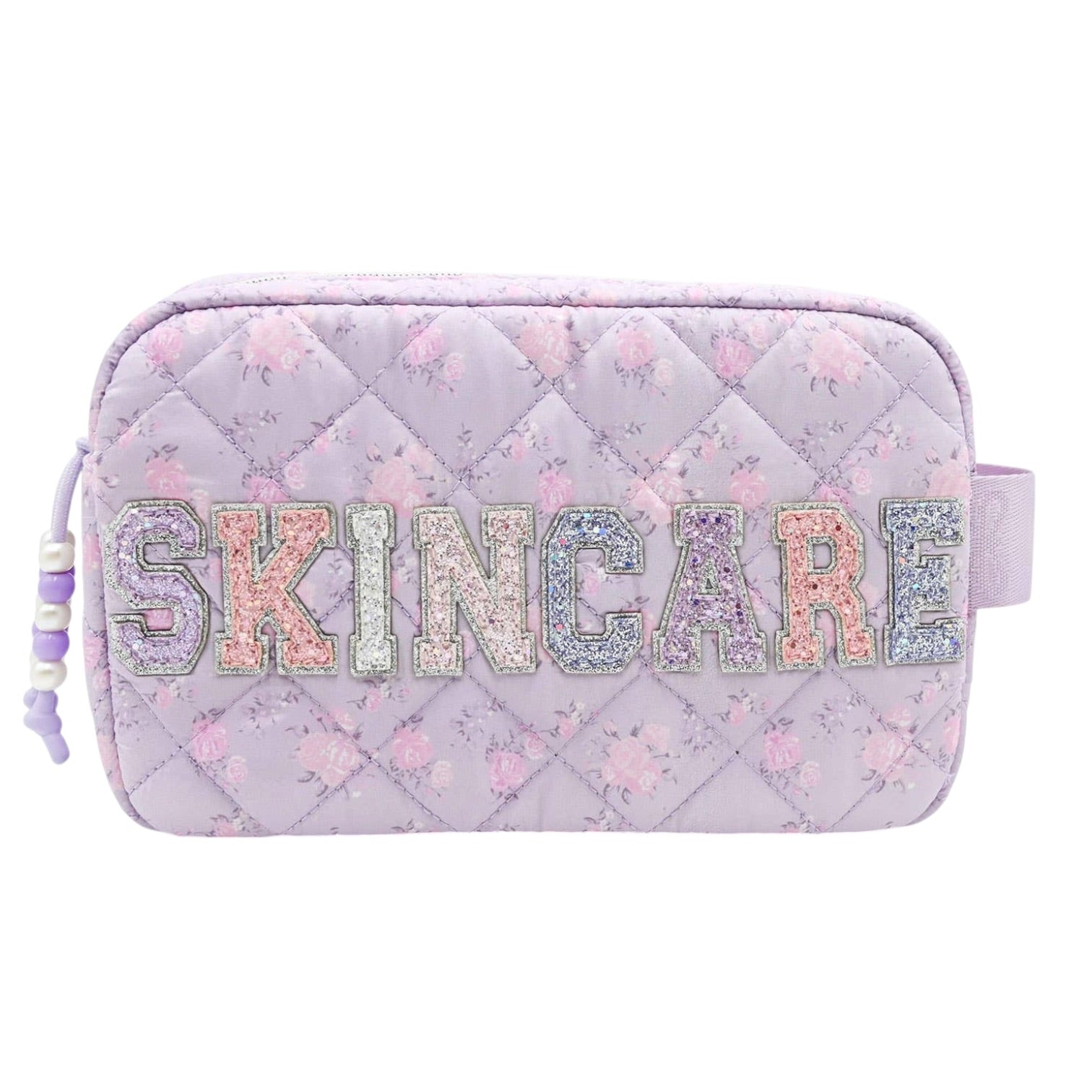 A light purple quilted cosmetic pouch with a floral pattern, featuring the word 'SKINCARE' in glittery, multicolored letters across the front. A lavender drawstring bag clip is visible on the left side.