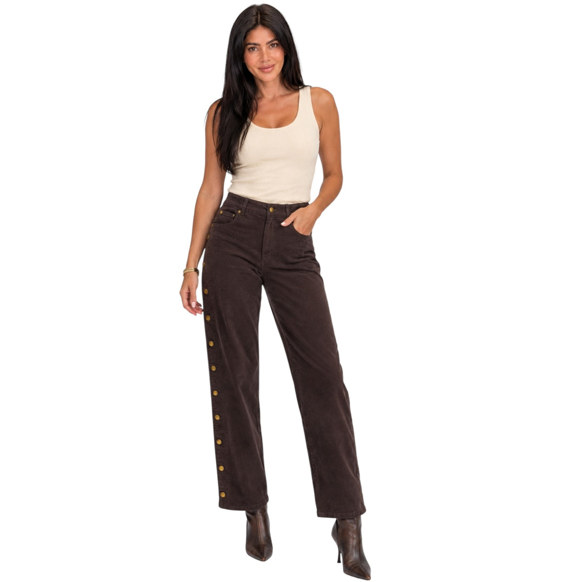 A woman modeling dark brown wide-leg pants with gold-tone decorative buttons down the side, paired with a cream tank top and brown ankle boots, against a plain white background.