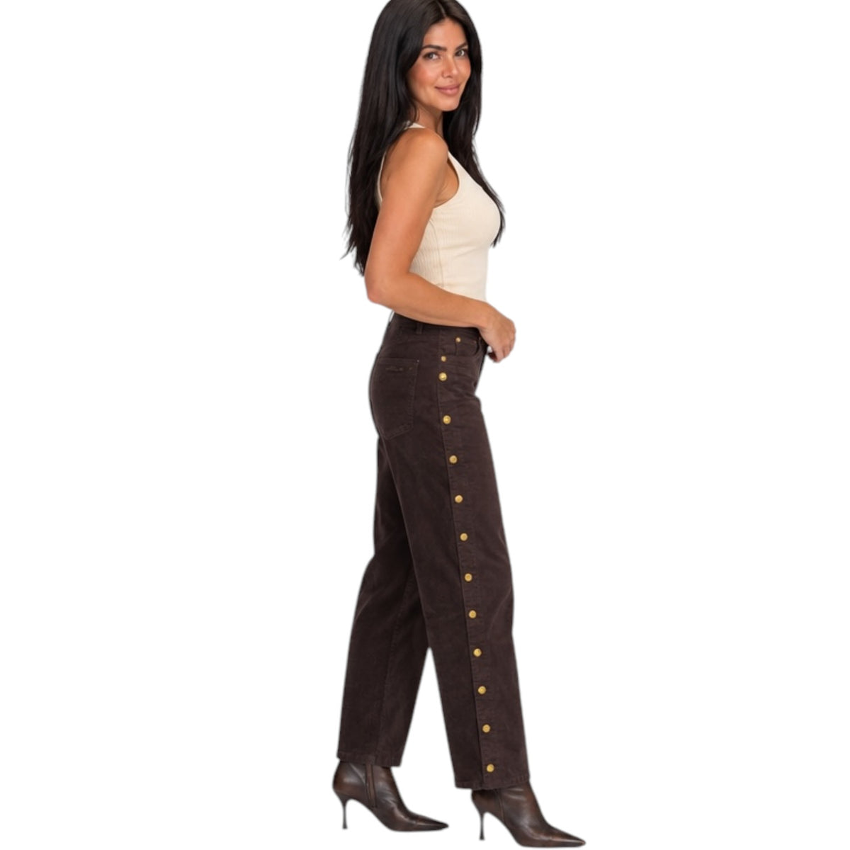 A woman modeling a pair of dark brown wide-leg pants with gold-tone decorative buttons down the side, paired with a cream tank top and brown pointed-toe heeled boots, set against a plain white background.