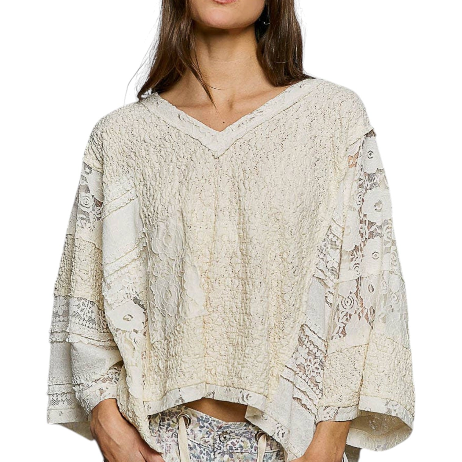 Woman wearing a beige lace top with a white background