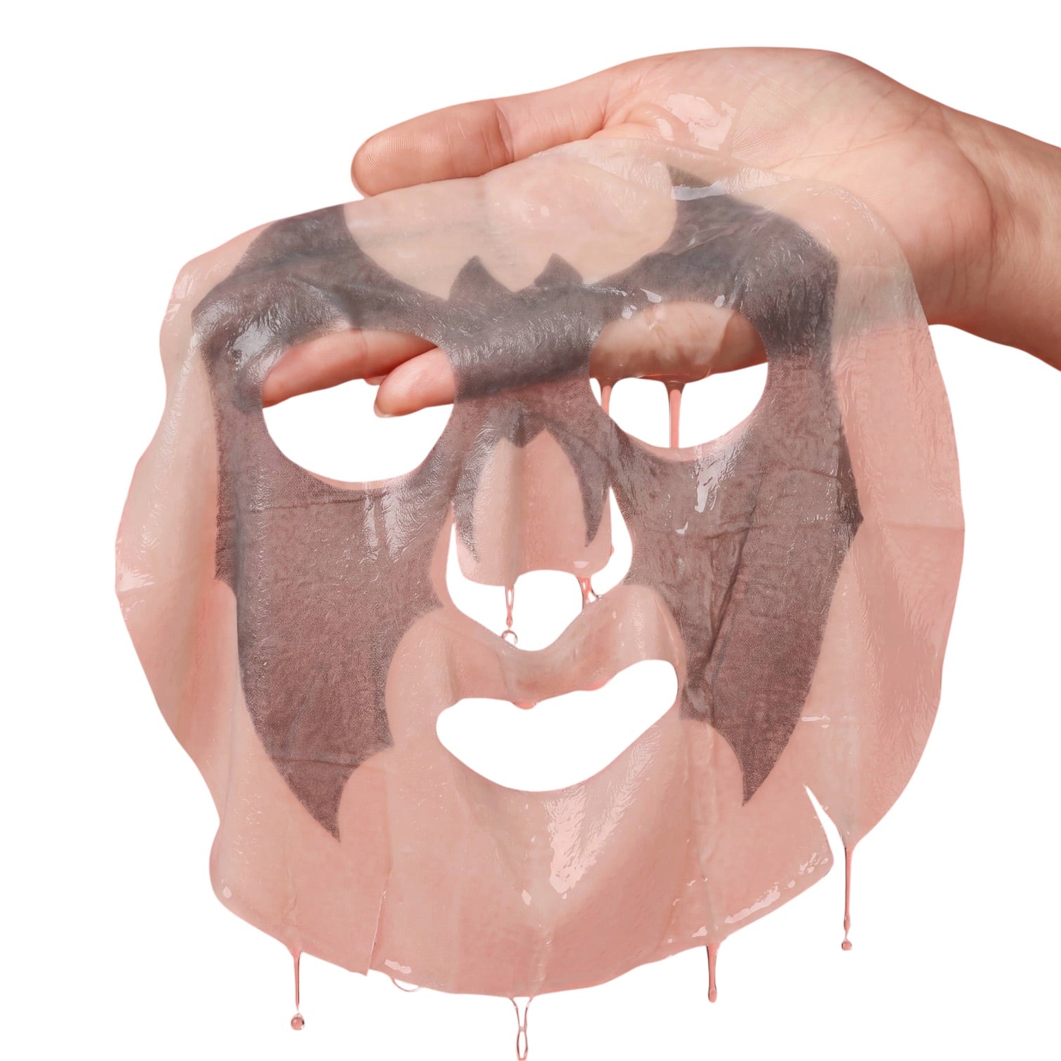 A translucent pink sheet mask with a dark charcoal-gray adhesive layer applied, being held by a hand against a plain white background.