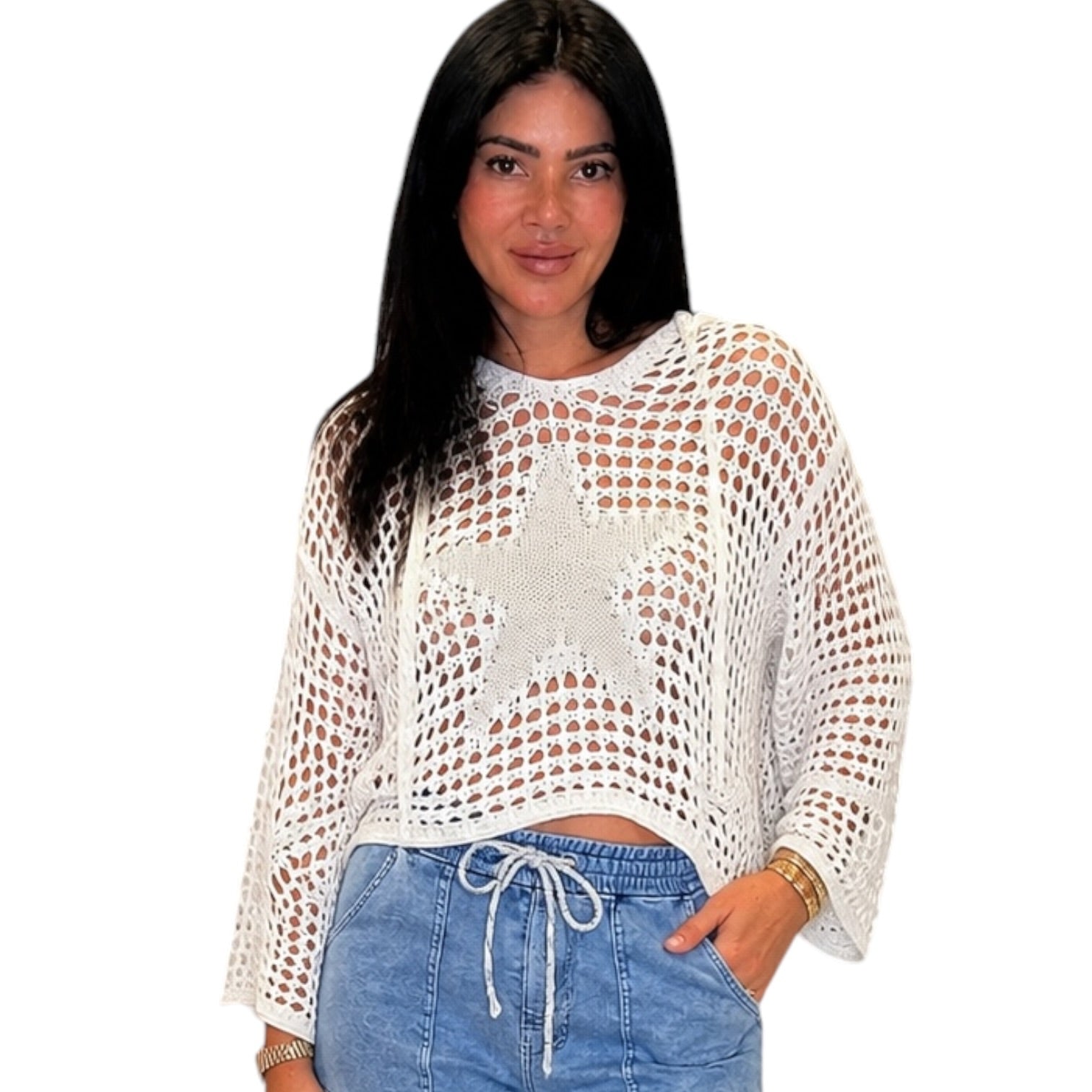 Woman wearing a white crochet top and blue jeans on a white background
