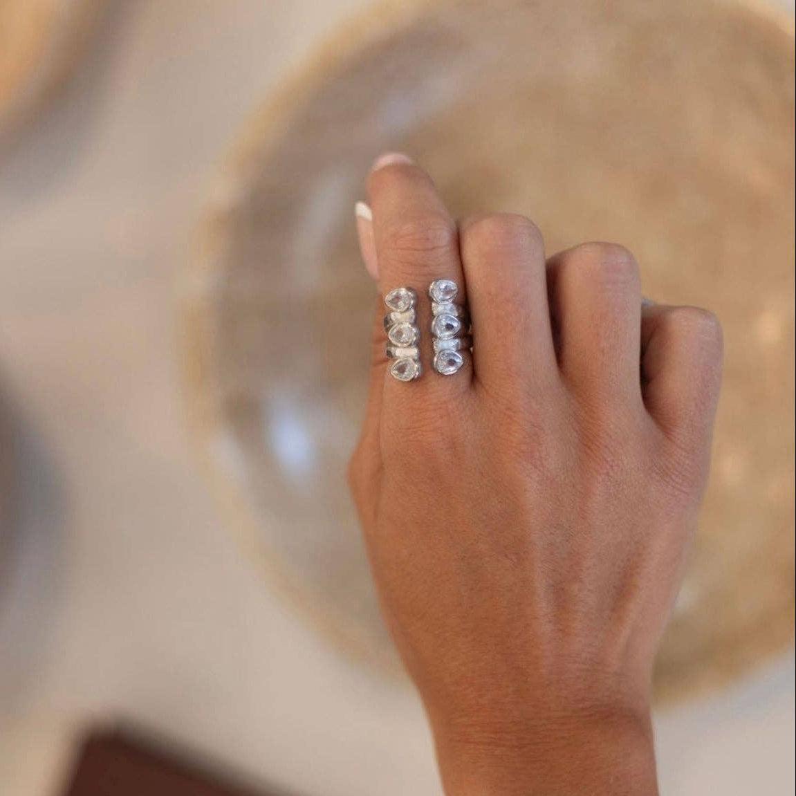 Hand wearing a ring with a blurred background