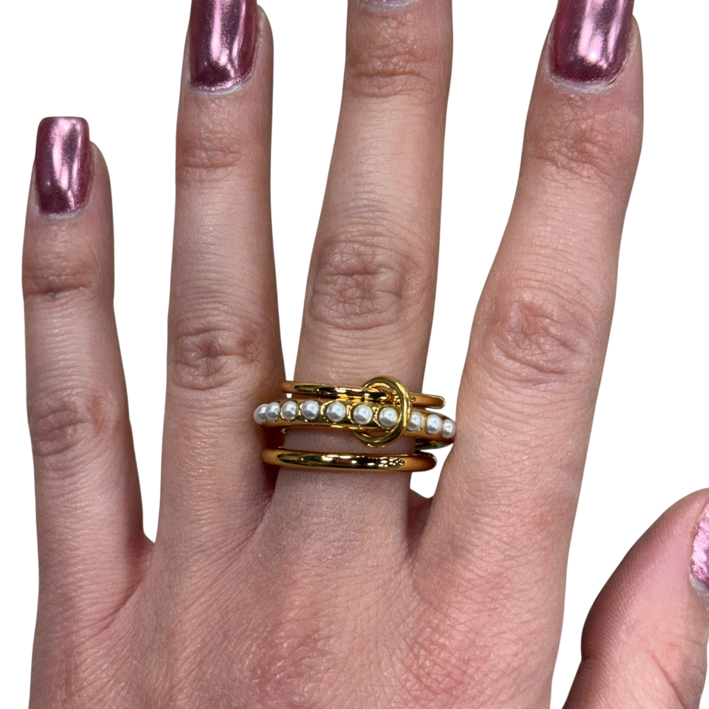 Gold ring with small stones on a hand with pink nail polish