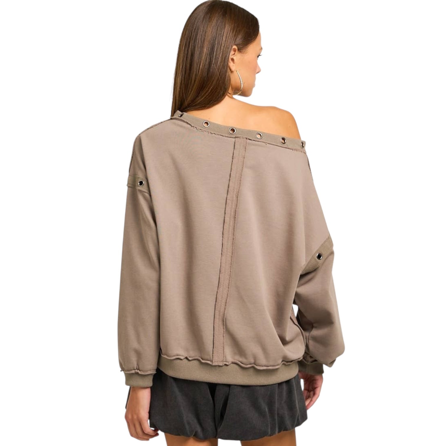 Woman wearing a beige off-shoulder sweater on a white background