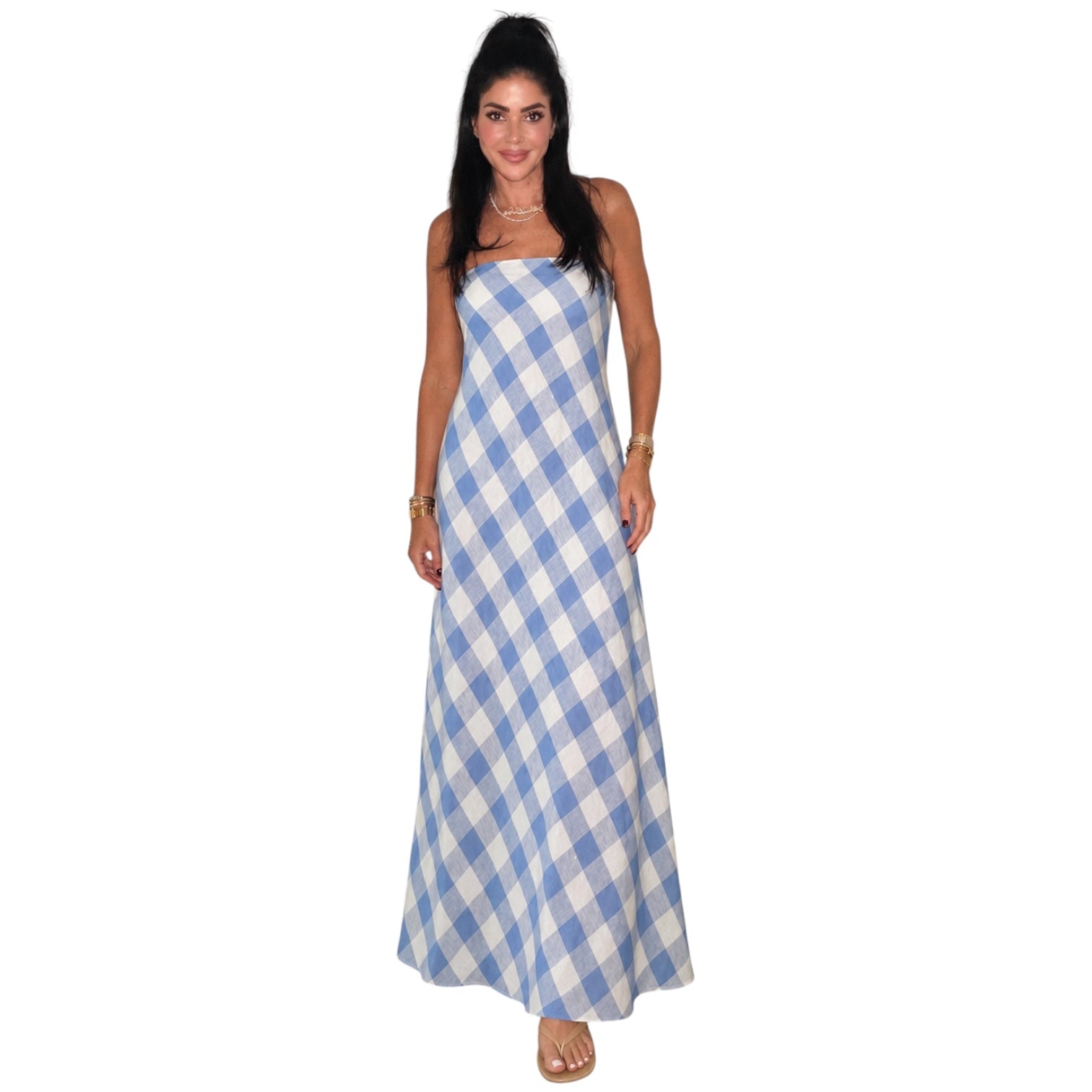 Woman wearing a blue and white checkered dress on a white background